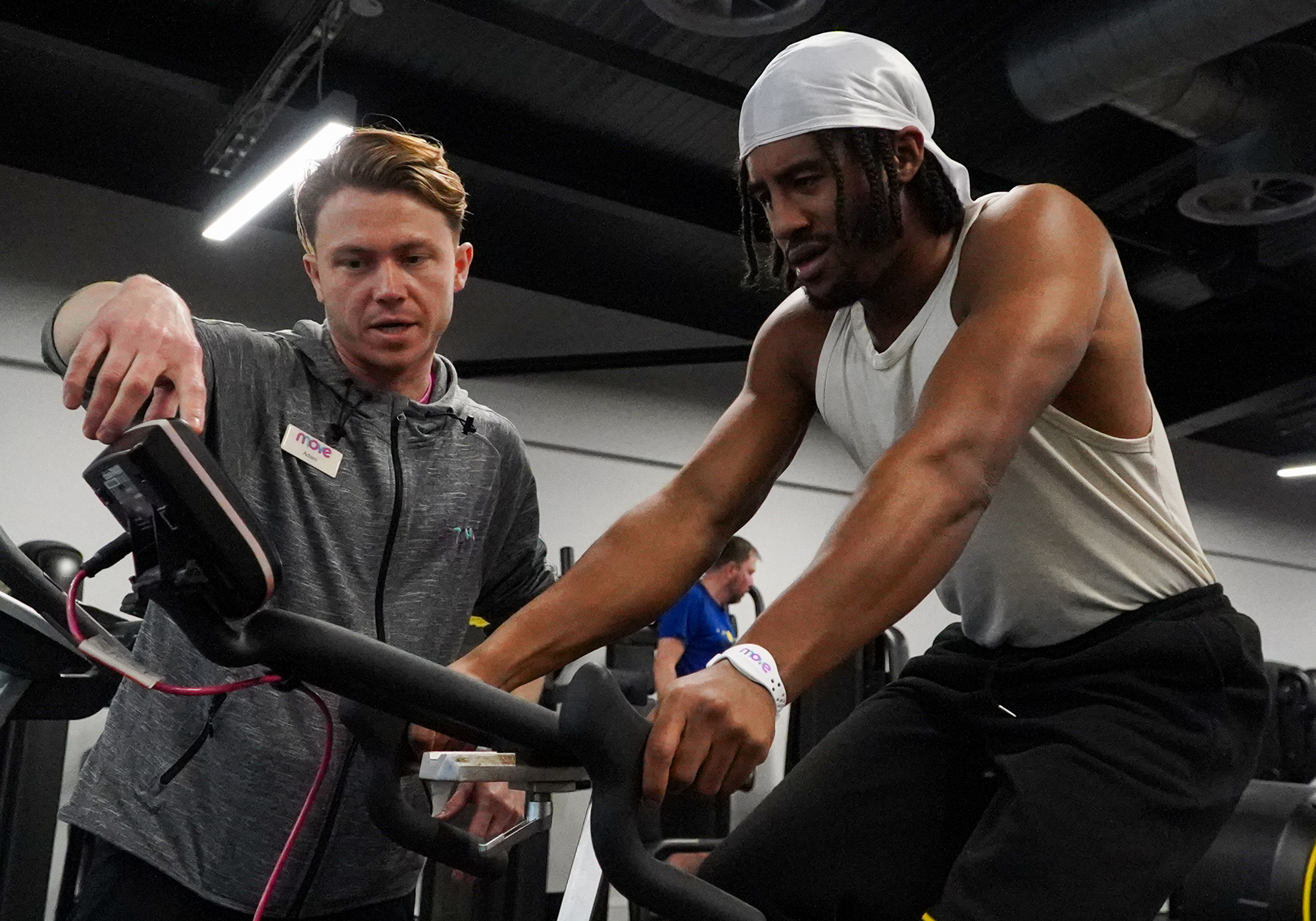 Member of staff helping a man in the gym